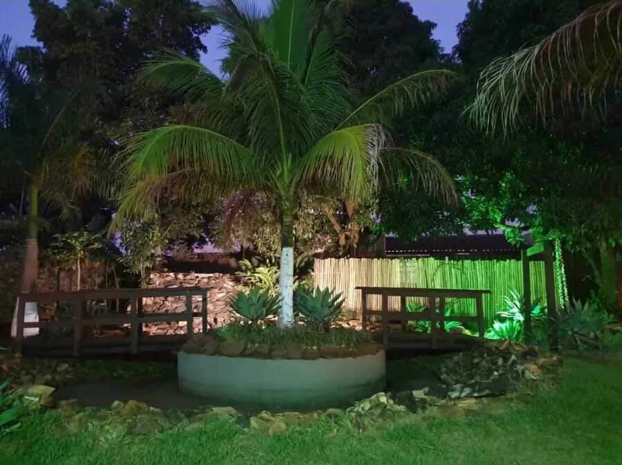 Área externa da New Fantasy com jardim iluminado à noite
